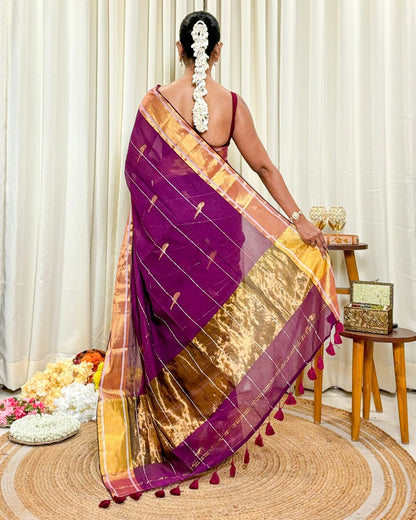 Women wearing handcrafted purple mulmul cotton saree with golden border for festive occasions