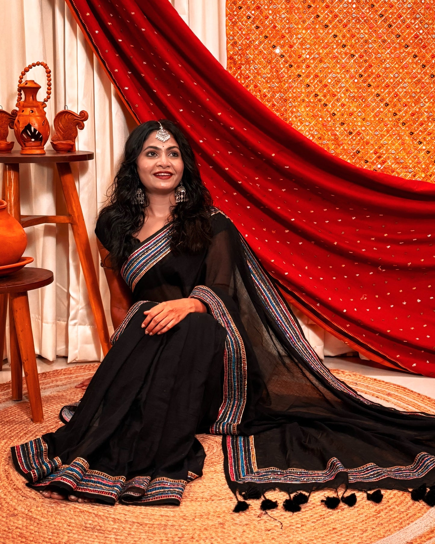 Woman in a black mulmul cotton saree with sequins embellished border - festive saree