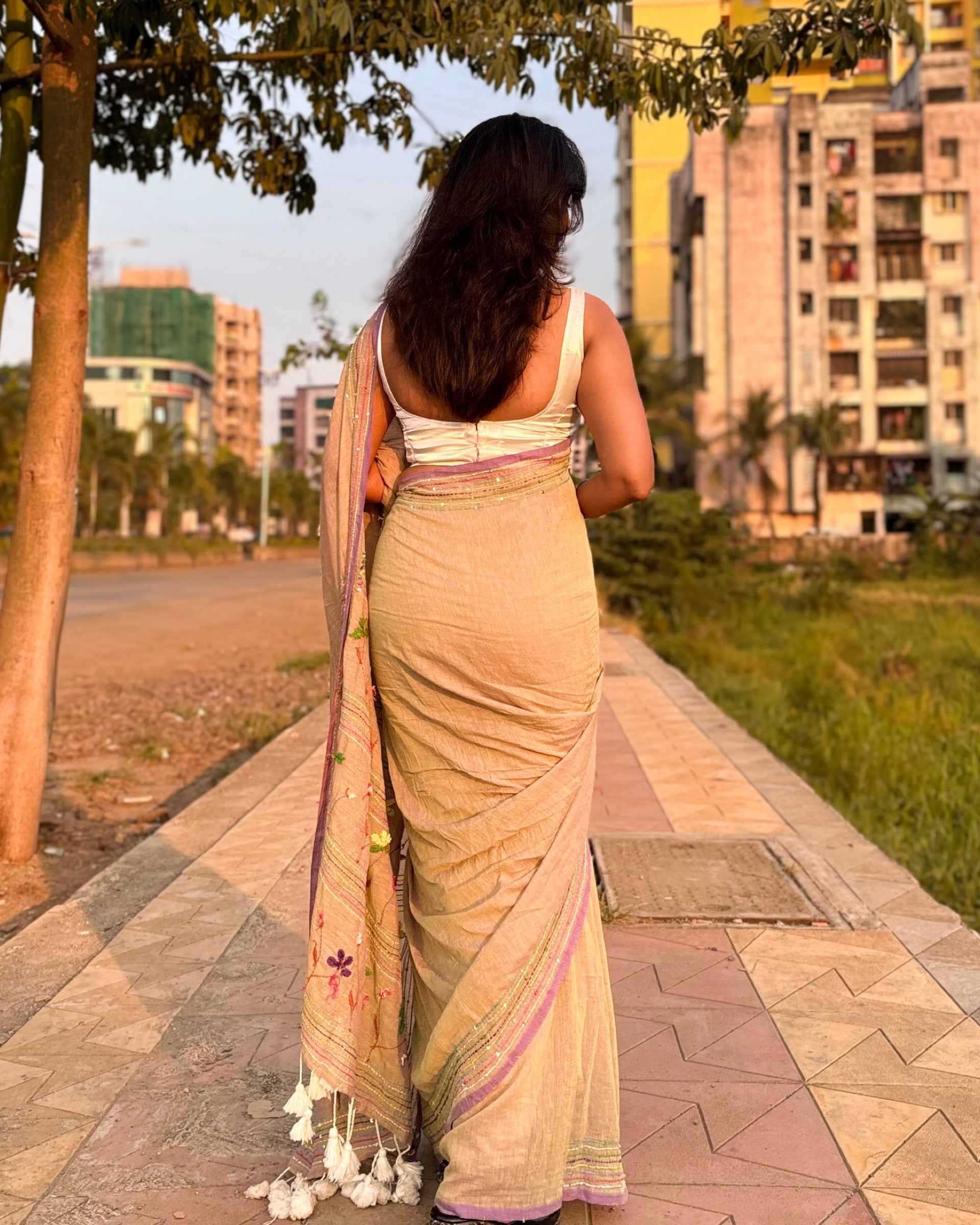 Beige mulmul cotton saree featuring elegant embroidered detailing