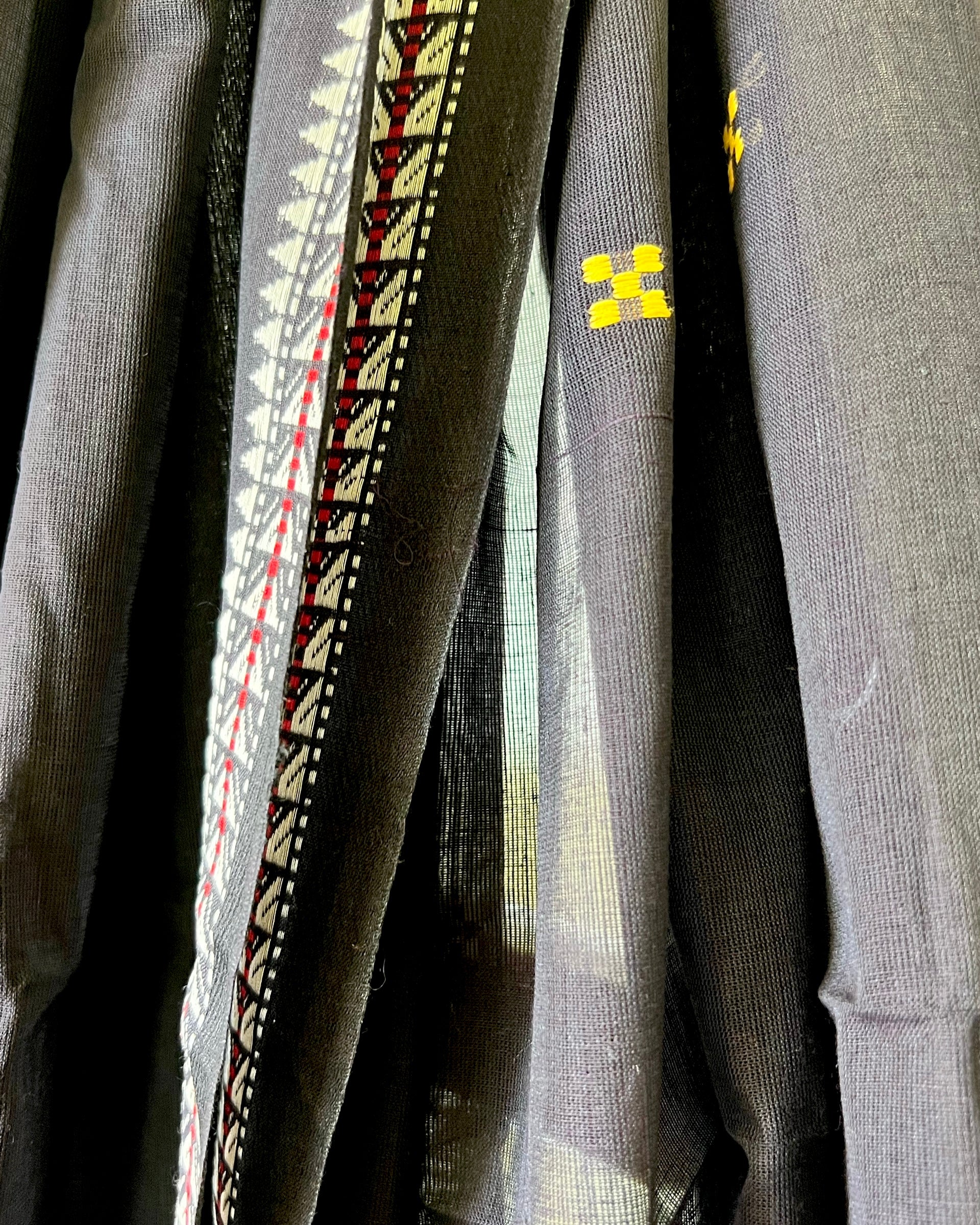 Close-up of a khadi cotton saree with intricate patterns and a brand logo.