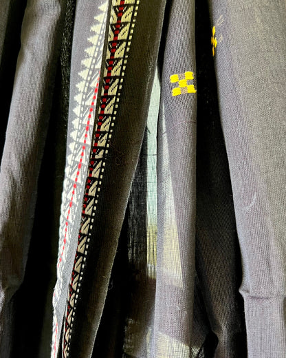 Close-up of a khadi cotton saree with intricate patterns and a brand logo.