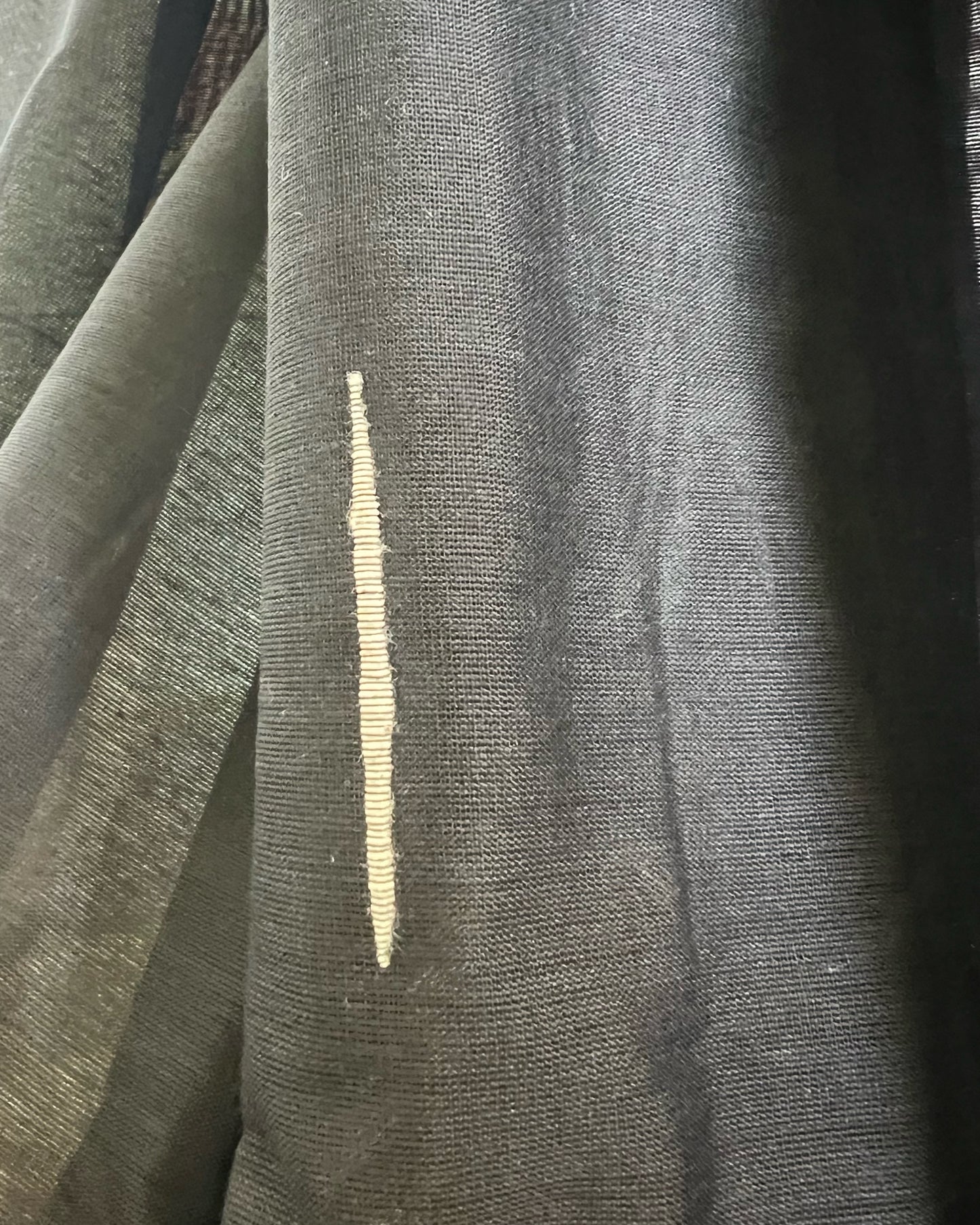 Close-up of black khadi cotton saree with a gold stripe