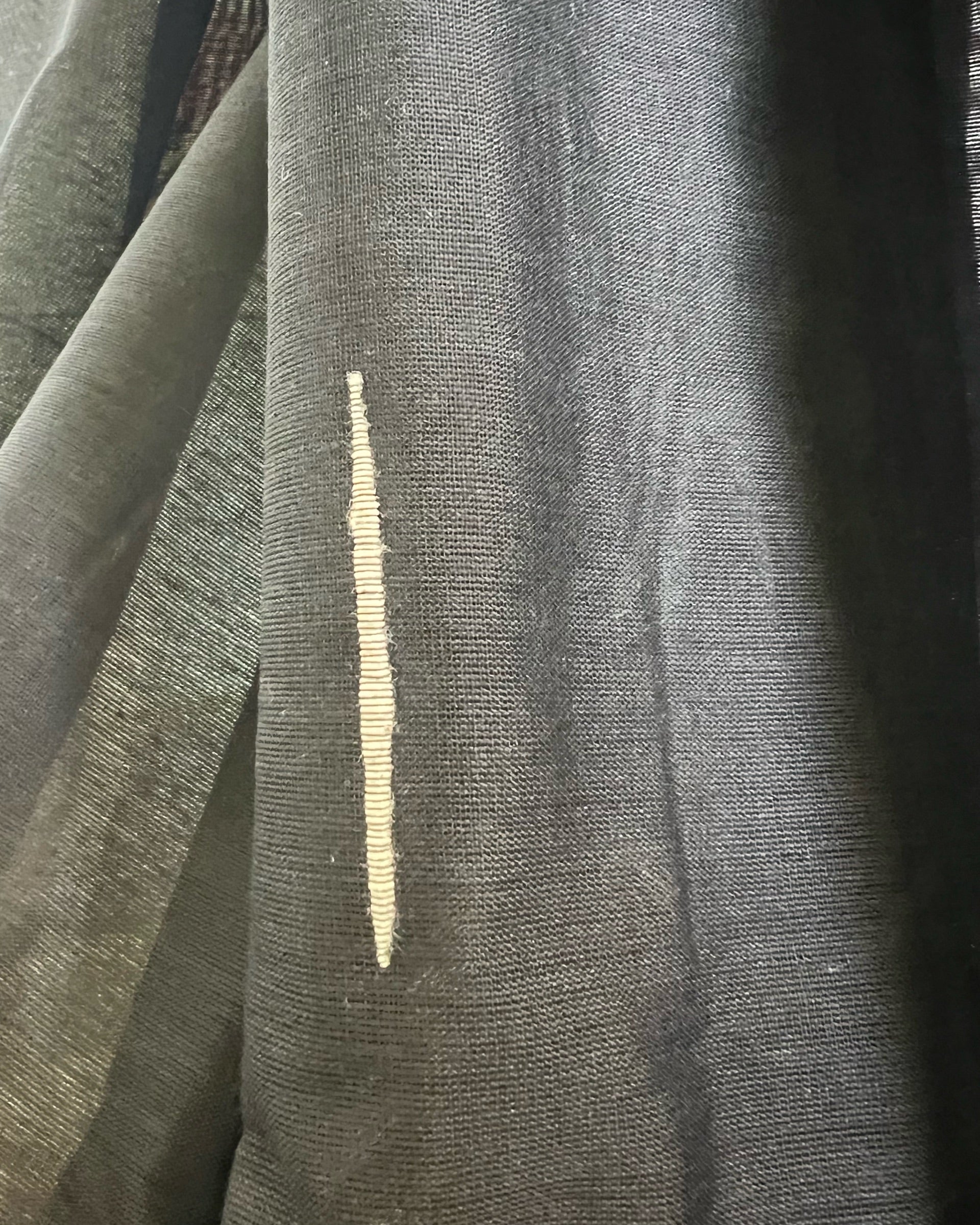Close-up of black khadi cotton saree with a gold stripe