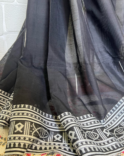 Black khadi cotton saree with white and gray patterns on a textured surface
