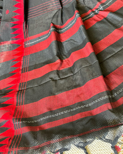 Close-up of a black and red striped khadi cotton saree with intricate patterns.
