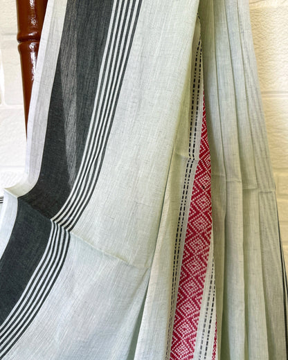 Khadi cotton saree with black, white, and red stripes on a wooden surface