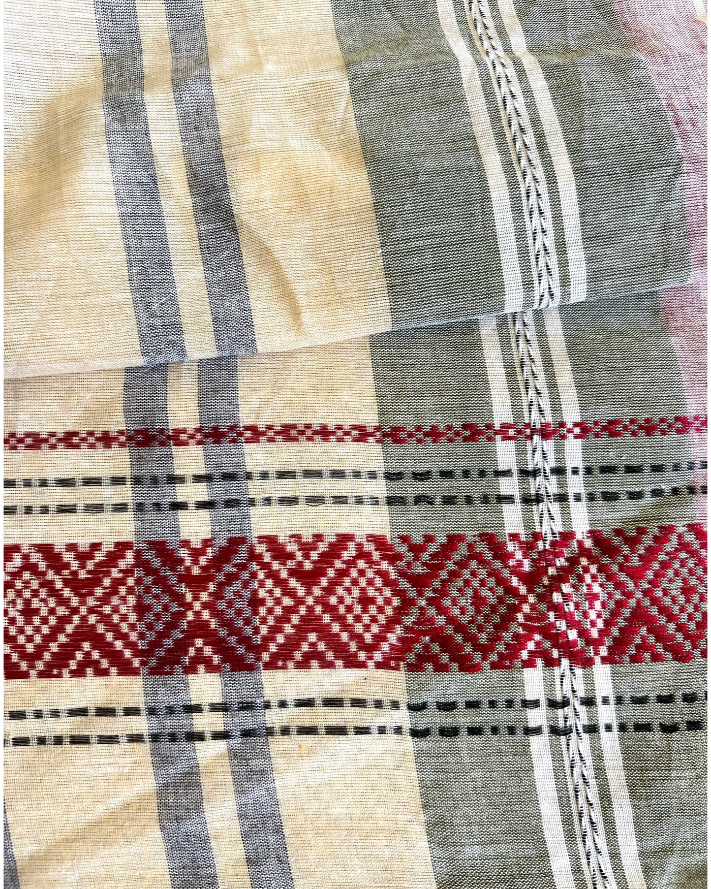 Close-up of pink khadi cotton saree with red, black, and beige patterns