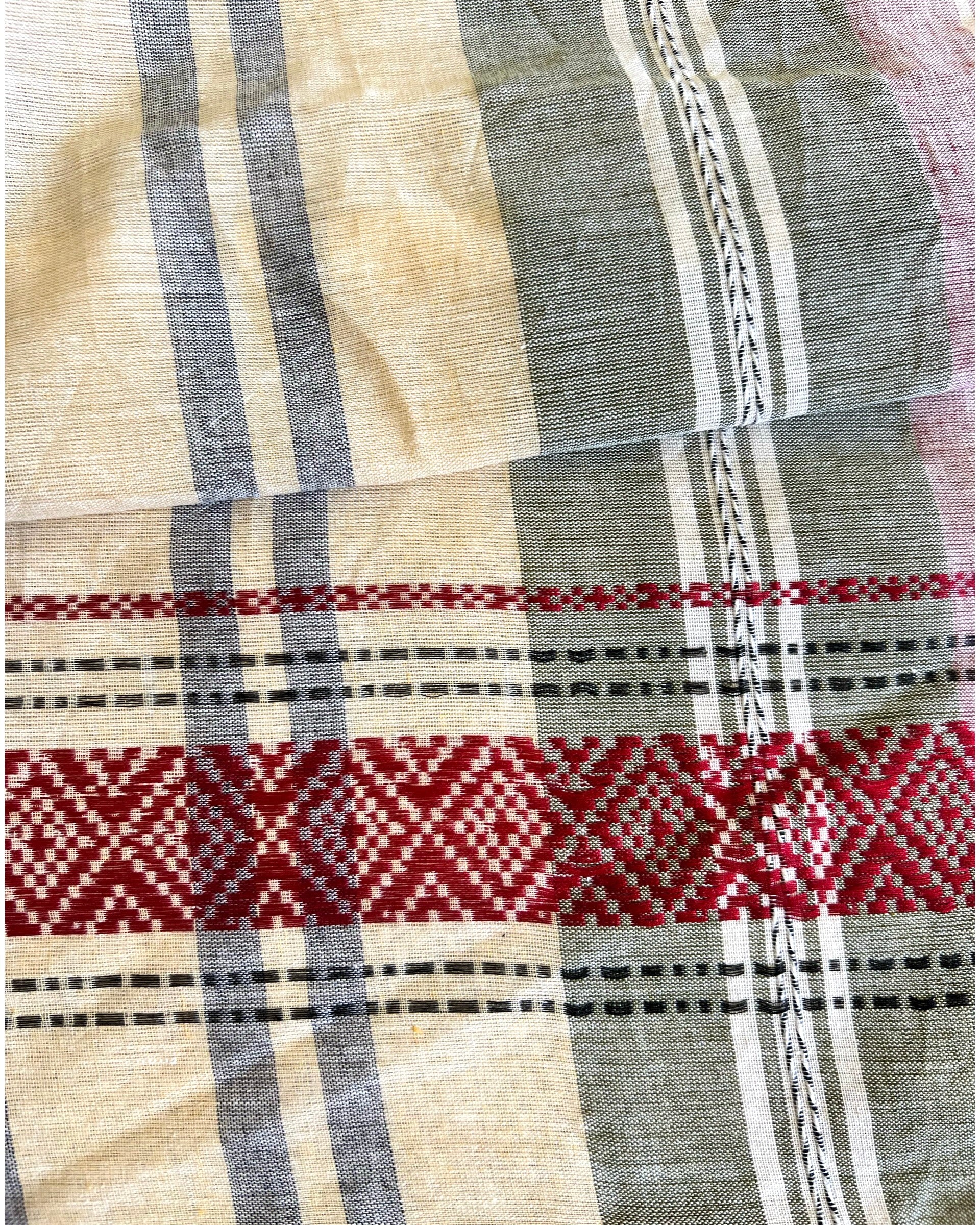 Close-up of pink khadi cotton saree with red, black, and beige patterns