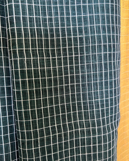 Close-up of green checkered handloom cotton Shopaame saree with a yellow border