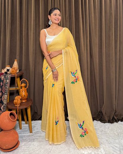 Woman wearing a yellow mulmul cotton saree by Shopaame with floral patterns against a brown curtain background