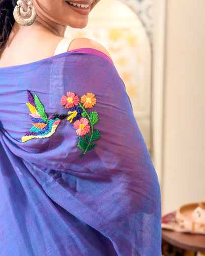 Purple mulmul cotton saree by Shopaame with floral embroidery on a blurred background